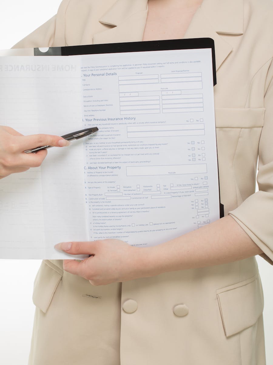 Close-up of a professional presenting insurance paperwork with a pen.